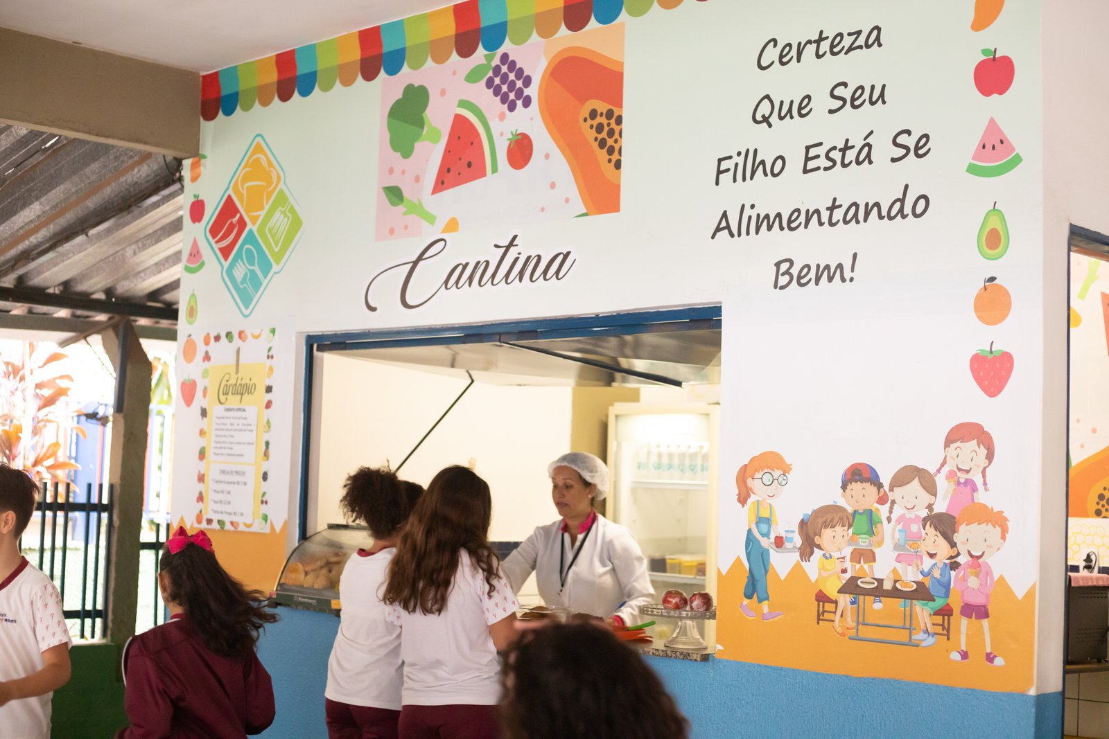 Cantina do Colégio Goyases, com mural colorido sobre alimentação e alunos na fila